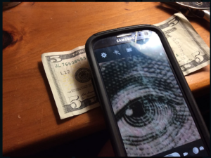 cell phone using macro lens hack to magnify five dollar bill